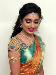 This is a low hanging bun famous as north indian bridal hairstyle for reception. Bridal Portraits Keerthana Looks Ravishing For Her Reception Ceremony Hair And Makeup By Wedding Saree Blouse Designs Bridal Blouse Designs Saree Hairstyles