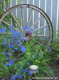Wagon Wheel And Flowers Garden Decor There Is No Such Thing As Too Much Cobalt Blue In The Garden Garden Wagon Wagon Wheel Decor Wagon Wheel Garden