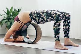 7 Ways To Use A Yoga Wheel Wheel Assisted Upward Facing Two Foot Staff Pose Yoga Wheel Wheel Pose Yoga Yoga Wheel Exercises