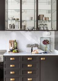 The walnut finish and black arts and crafts hardware are helpful in blending into any decor. A Gallery Of Gorgeous Glass Fronted Cabinets All The Beauty Of Open Shelving Without The Dust Grime Glass Fronted Kitchen Cabinets Glass Shelves Kitchen Glass Kitchen Cabinets