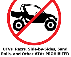 Image of UTV on a road with a No UTVs sign