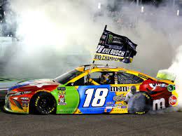 Kyle busch, driver of the #18 m&m's toyota, hoists the trophy after winning the monster energy nascar cup series ford ecoboost 400. Kyle Busch Captures Second Career Nascar Cup Series Title