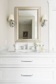 Classic White Bathroom Vanity With White Marble Countertop Polished Nickel Hardware And Polished Nickel Sconces Flanking Mirror Classic White Bathrooms White Vanity Bathroom White Bathroom Interior