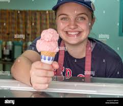 High school girl scooping up ice cream for a customer Stock Photo