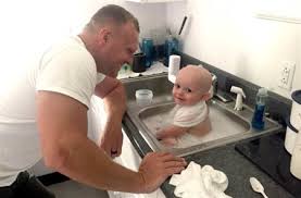 Un oficial de policía baña a un bebé que estaba cubierto en vómito tras  arrestar a su madre que conducía borracha