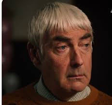 If I may be so bold, I would like to recommend Mr. Colin Robinson as the  Patron Saint of the Dull Men's Club, granted he may be a vampire, but he by