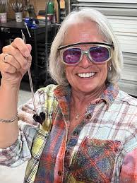 Young ladies create glass heart pendants in class