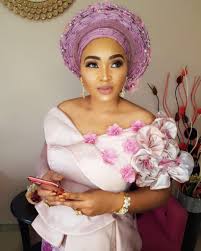 On the back, there is a small lace element and the whole blouse has a unique design. Mercy Aigbe Asoebi Styles Fashion Fashionstyles Ankaraandplainmaterial Ankaracombo Modernst African Wedding Attire Traditional Wedding Attire Asoebi Styles