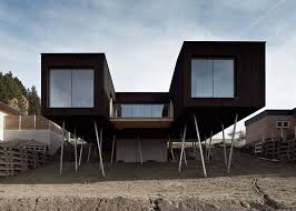 The plaque floats about a quarter inch off the wall and is held with a handmade metal cleat (included) for ease of hanging. Black Painted S House By Hammerschmid Pachl Seebacher Raised On Stilts