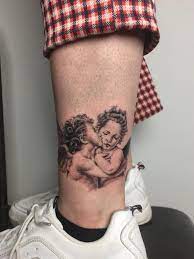 The First Kiss Cherub Tattoo Back Tattoos For Guys Thigh Tattoo