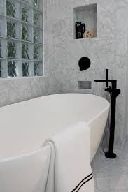 Freestanding carrara marble bathtub carved from a solid natural block of marble. Elegant Carrara Marble Tile Surround This Freestanding Tub And Faucet Free Standing Tub Carrara Marble Tile Marble Tile