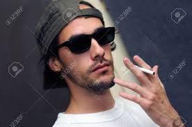 It's also used to express appreciation or approval and to stand in for the sentiments of ok or awesome. Portrait Of Young Guy Holding Cigarette With Cool Look And Sunglasses Stock Photo Picture And Royalty Free Image Image 5958071