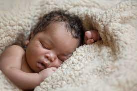 Cute yawning infant baby on mothers hands in room. Research On Newborn Babies Shows Inbuilt Ability To Pick Out Words