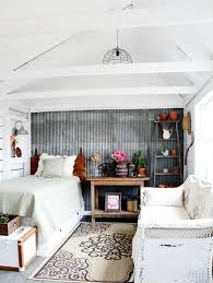 A contemporary farmhouse bedroom in neutrals, with a black metal bed, a metal sphere chandelier, a boho rug and a wreath. Farmhouse Style Guest Bedroom Best Home Style Inspiration