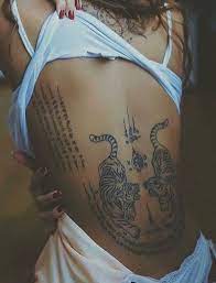 Two Tigers With Thai Scripture Tattooed On The Back Www Otziapp Com Tattoos Back Tattoos Hip Tattoo