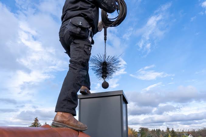 Chimney sweep technician at work