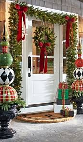 Whimsy Porch Decor With Evergreen Garlands Lights Large Ornament Topiaries And Indoor Christmas Decorations Front Porch Christmas Decor Christmas Porch Decor