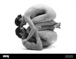 Hombre y mujer desnuda en posición fetal, la mujer encima del hombre,  frentes de tocar, B&W Fotografía de stock 