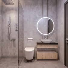 This minimalist bathroom features concrete floors and walls, a frameless mirror, and brass shower fixtures. Industrial Bathroom Ideas That Are Ultra Chic