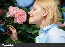 Adoro rosas. A mulher jovem no momento da floração aumentou arbusto. Mulher  bonita cheiro rosa flores no jardim de verão. Mulher adorável desfrutar  flor flor. Flor de flor de verão — Foto ©