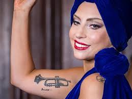 Another of lady gaga's earlier tattoos is this design of three daisies on her left shoulder. Lady Gaga S Trumpet Tattoo On Bicep