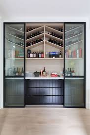 Chevron Pattern Wine Storage Behind Black Framed Glass Sliding Doors Black Wall Decor Glass Shelves Kitchen Black Walls