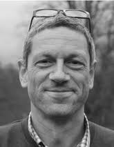 2D Material Microcavity Light Emitters: To Lase or Not to Lase?