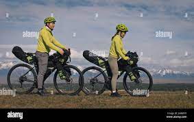 The man and woman travel on mixed terrain cycle touring with bikepacking.  The love couple journey with tent in nature with bicycle bags. Stylish bikep  Stock Photo - Alamy
