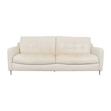 A leather sofa that takes on a bit of a different form with its single tufted cushion and bolster. White Leather Tufted Sofa