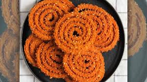 Chakli, spiral shaped crispy snack made from rice flour and spices, served on a plate