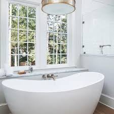 Wood barn doors, cabin, chandelier over tub, custom home, master bath, mountain home, natural materials, wood ceiling inspiration for a farmhouse medium tone wood floor and brown floor bathroom remodel in salt lake city with white walls love the wood floors and ceiling as well as the windows. Chandelier Over Tub Design Ideas