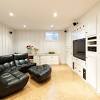 Neutral basement features a sectional and wood accents. 3