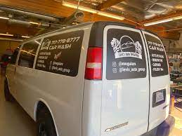 White Van With Promotional Black Window Wraps Front Signs