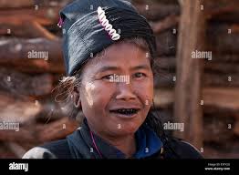 Frau des Stammes Ann mit einem schwarzen Zähne Lächeln in ihrem Haus in  einem Dorf um Kengtung, Shan State in Myanmar Stockfotografie
