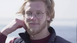 Un Hombre Rubio Con Gafas Y Barba Ayuda a Su Hijo Pequeño Un Niño Albino  Con Gafas De Cabello Blanco a Arreglar Su Metrajes