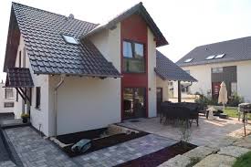 Eine überdachte terrasse am haus besteht aus einer dachkonstruktion mit stützen und seitenwänden. Unmittelbarer Stein Terrassenanschluss An Hausfassade