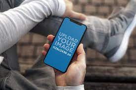 Hands holding an iphone at a photographer desk. Iphone X Mockups Mockup Generator Placeit