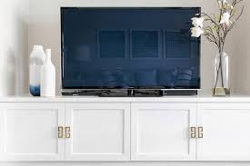 Dove by maria yee inc. Gold Greek Key Hardware On A Low White Tv Cabinet Finished With Shaker Doors Built In Tv Cabinet Tv Cabinet Design White Tv Cabinet