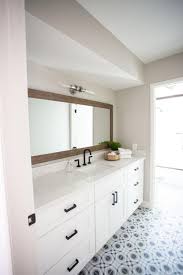 Standard bathroom vanity tops vs wood vanities. A Long Wood Framed Mirror Runs Parallel To The Marble Vanity Countertop With Backsplash Lip Black Stylish Bathroom White Vanity Bathroom Bathroom Mirror Frame