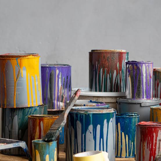 Latas de tinta coloridas empilhadas em obra