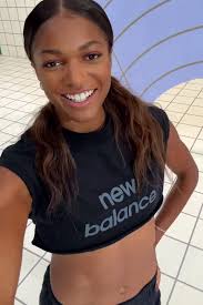 Gabby Thomas' toned abs shine in crop top New Balance fit