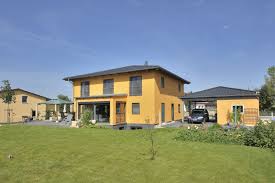 leuchtend gelb verbreitet diese klassische stadtvilla mit integrierter garage ganzjahrig gute laune viele fensterflachen mit rah stadtvilla villa fassade haus