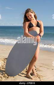 Young girl posing on the beach with board Stock Photo - Alamy