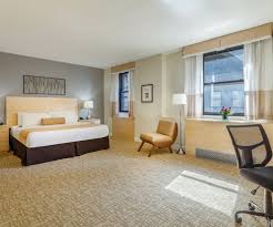 A living area and two sleeping rooms, one with two double beds and another with a king bed. Hotels In Midtown Manhattan Affordable Rooms Hotel Penn