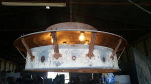 One Of Farm Factory Interior S Chandeliers Made From A Chicken Brooder Hog Feeder And Turkey Feeder Rustic Chicken Brooder Repurposed Lamp Factory Interior