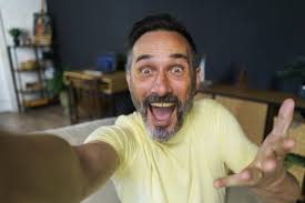 Bell'uomo caucasico di 40 anni che fa un ritratto selfie al chiuso a casa  Ragazzo brizzolato felice che sorride alla telecamera