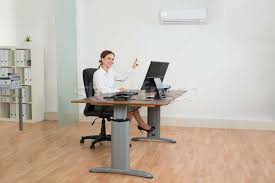 Smart functionalities include a smartphone app to control your ac. Businesswoman Using Air Conditioner In Office Stock Photo C Andreypopov 6097180 Stockfresh