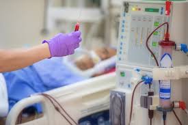 Clinical setting with apheresis or dialysis equipment, blood tubing, gloved clinician with sample, and patient in bed