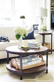 A vase full of flowers (or faux greenery) adds height to the low table and brings in some color and freshness. Simple Round Coffee Table Styling Ideas On Sutton Place