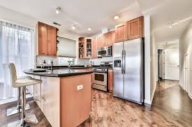 Modern Kitchen With Light Wood Cabinets Black Granite Countertops Stainless Steel Appliances Black Granite Countertops Countertops Granite Countertops Price